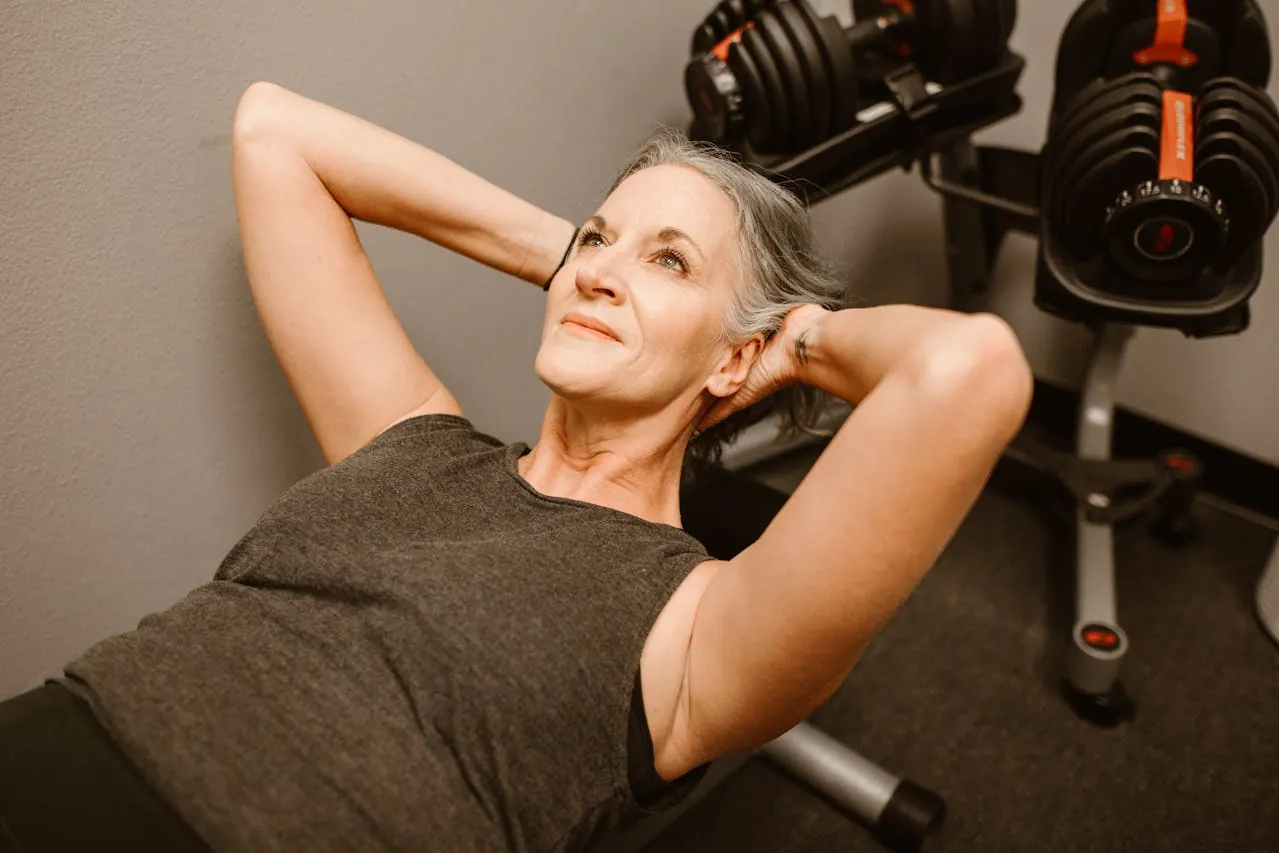 Older woman doing crunches on a workout bench